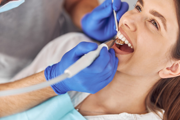 a patient is receiving dental cleaning treatment in a dental office.