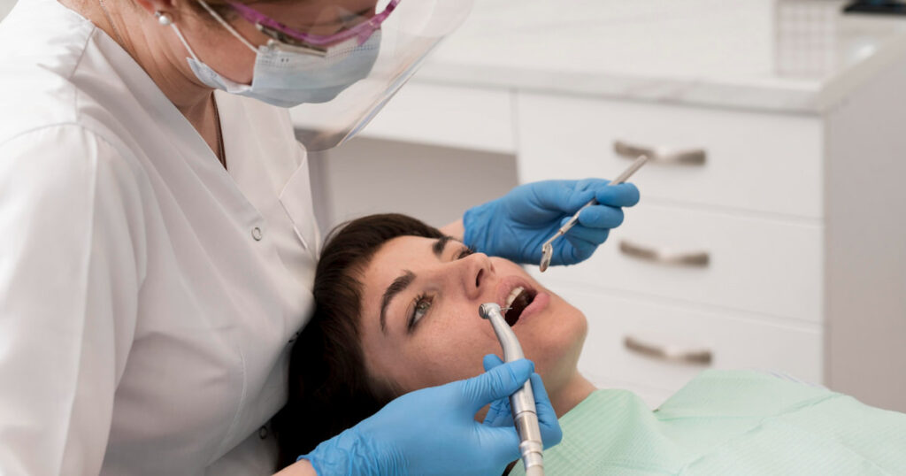 a dentist is performing professional dental cleaning on a patient in a dental office.