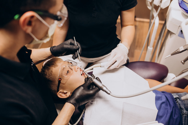 a child is receiving professional dental cleaning in a dental office. 