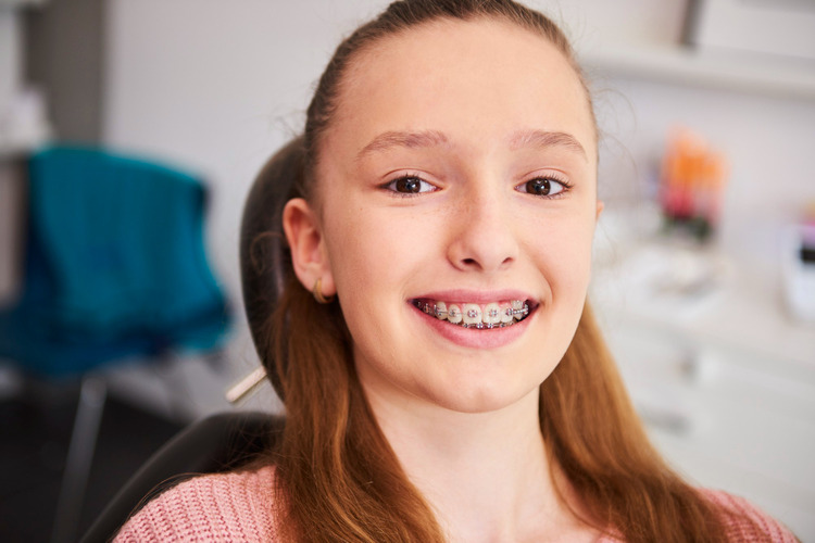 A teenage girl in a dental clinic with braces installed on her teeth.