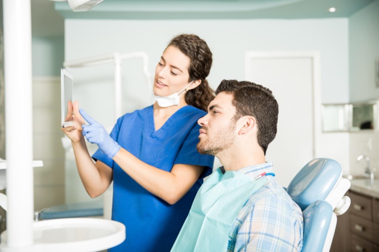 Female dentist in a clinic explaining aftercare and recovery tips to a patient after emergency dental treatment