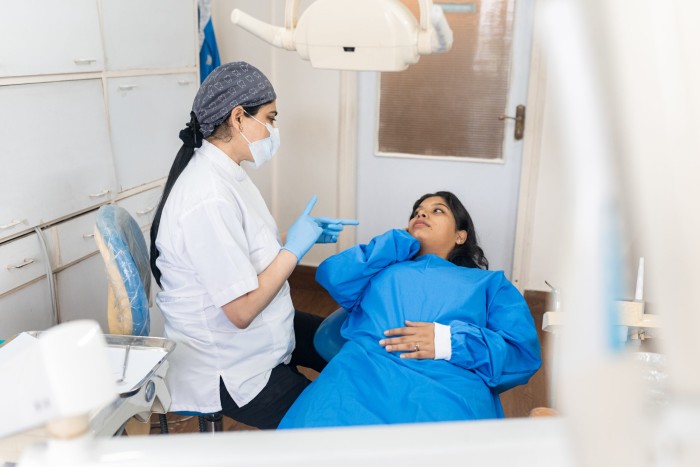 A female dentist explaining to a patient that they may experience some tooth sensitivity after teeth whitening